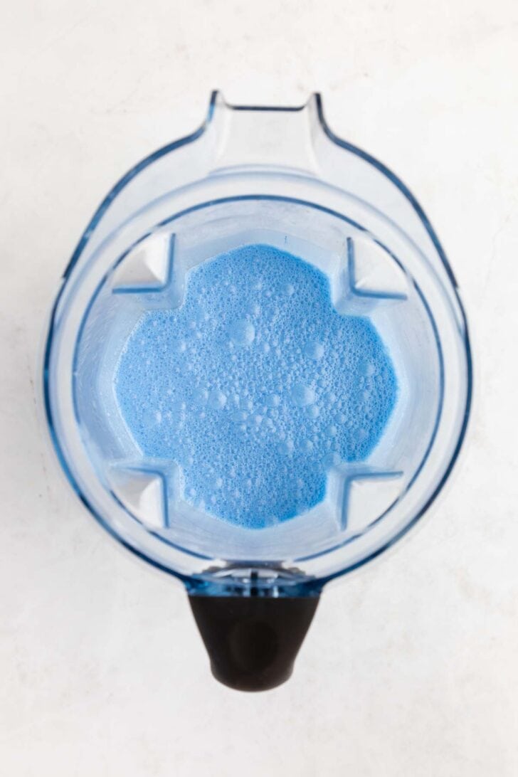 blended coconut milk, sugar, and blue spirulina inside a vitamix blender